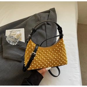Detail of yellow velvet shoulder bag with pearl accents and black leather strap