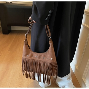 Nahaufnahme der braunen Wildledertasche mit langen Fransen und silbernen Sternnieten