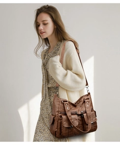 Detail of vintage brown soft leather tote bag with multiple pockets and silver hardware