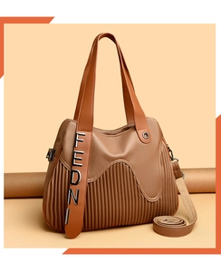 Vue détaillée d'un sac à main marron en cuir avec plis et lettres métalliques argentées