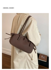 Sac porté épaule en cuir marron mat avec cordons et détails tressés porté par mannequin