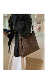 Detailed close-up of dark brown woven tote bag with intricate checkerboard texture