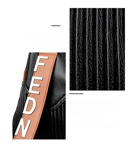 Détail de la texture cuir plissé noir et bandoulière marron avec lettres FEDN