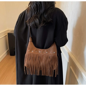 Braune Wildleder-Hobo-Tasche mit silbernen Stern-Nieten und langen Fransen getragen