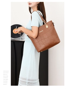 Detail of vintage brown tote bag featuring crocodile embossed patterns and gold hardware