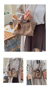 Close-up of brown canvas crossbody bag featuring colorful wooden beads and leather straps