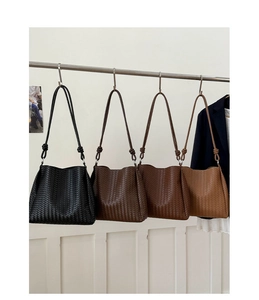 Row of woven bucket bags in four colors showing high-capacity design and knotted straps