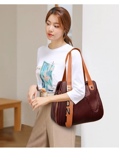 Détail du sac cabas bordeaux en cuir grainé avec plis et anses contrastées orange