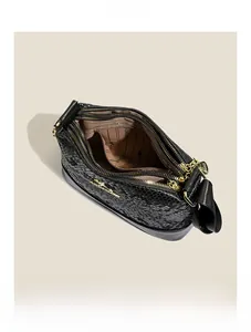 Detail of black snake pattern Boston bag interior with zipper pocket and metal kangaroo tag