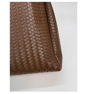 Close-up of brown woven bucket bag featuring detailed checkered weave pattern and texture