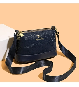 Detail of navy blue snakeskin texture purse with gold kangaroo logo and wide strap