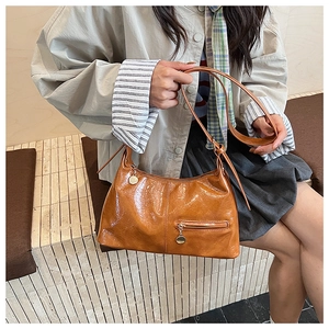 Detail of vintage brown oil wax leather bag with functional front zip pocket