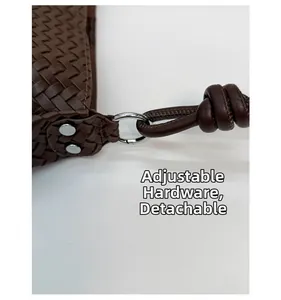 Detail of coffee woven leather bucket bag with silver metal ring and adjustable knot strap