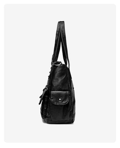 Side view of black PU leather moto tote bag with side pockets and metallic snap buttons