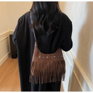 Braune Wildleder-Fransentasche mit Sternnieten und Boho-Stil an einem Modell