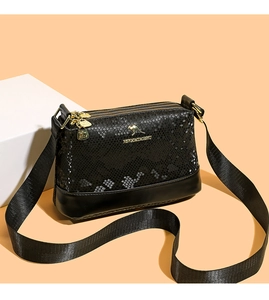 Detail of dual-texture black Boston bag with snake skin embossing and gold zippers