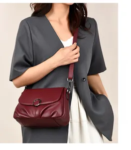 Detail of burgundy pebbled leather handbag with silver ring clasp and pleated design