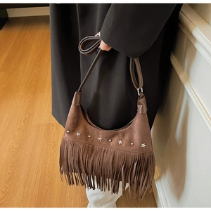 Detail der dunkelbraunen Wildlederimitat-Tasche mit Silbernieten und langen Fransen
