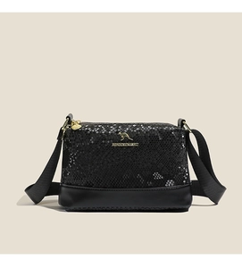 Detail of black faux snake skin texture and golden kangaroo logo on the stylish crossbody bag
