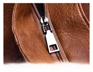 Macro detail of high-quality silver metal zipper on premium brown litchi grain leather