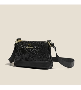 Detail of black snake pattern texture on Boston bag with golden kangaroo logo accent