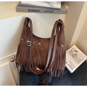 Detail der braunen Wildledertasche mit silbernen Sternnieten und Boho-Fransen-Deko