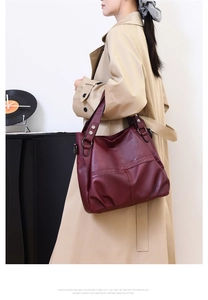 Detail of burgundy PU leather tote bag with silver metal ring buckle and rivet accents