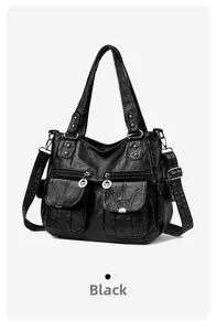 Close-up of black vintage biker tote bag with silver zippers and dual front pockets