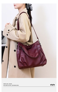 Close-up of burgundy PU leather tote showing pebble texture and metal buckle detail