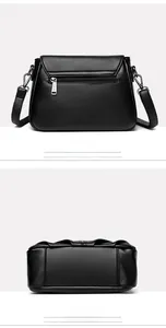 Detail view of the black textured leather bag showing the back zipper and flat bottom seams