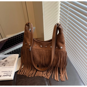 Detailansicht der Fransen und silbernen Sternnieten auf brauner Vintage-Wildledertasche