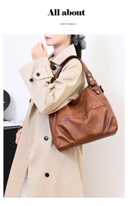 Detailed texture of brown vintage PU leather tote bag worn by a model in a trench coat