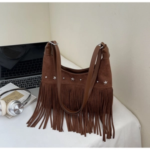 Detail der braunen Wildleder-Hobo-Tasche mit silbernen Sternnieten und langen Fransen