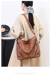 Brown vintage PU leather tote bag with metal studs shown in a lifestyle setting