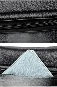 Detailed macro view of black lychee leather stitching and functional back pocket of a bag