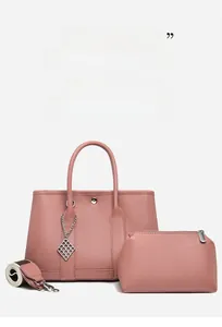Detail of dusty pink lychee grain leather tote bag set with wide woven strap and charm