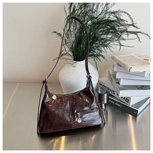 Detail of dark brown oil wax leather shoulder bag with silver zipper and vintage texture