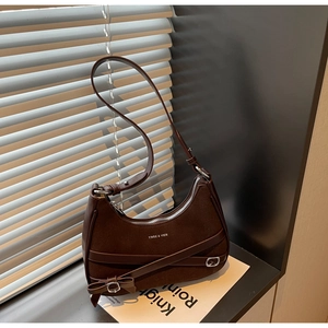 Détail du sac croissant marron foncé avec boucle à nœud et logo YNGE & VIER texté