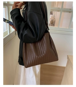 Detailed close-up of dark brown woven tote bag texture and high-quality leather material