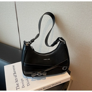 Gros plan sur le sac hobo noir en daim avec logo YNGE & VIER et détail de nœud