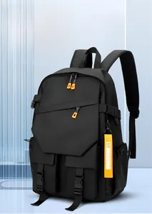 Detail of black multi-functional backpack with orange zipper accents and thick shoulder straps