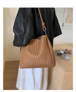 Detail of a brown woven leather bucket bag featuring a unique knotted shoulder strap design