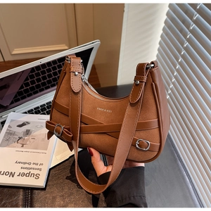 Détail du sac bandoulière demi-lune marron vintage avec texture daim et boucle métal