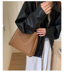 Close-up of brown woven leather texture on a bucket bag styled with a leather jacket