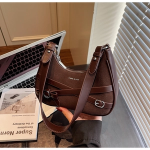 Détail d'un sac à bandoulière rétro marron foncé avec texture en cuir de qualité