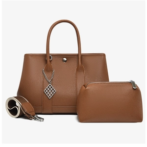 Close-up of brown litchi pattern leather tote set with silver hardware and woven strap