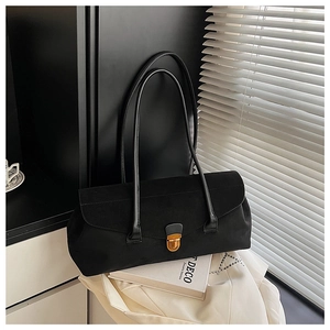 Detailed view of black matte bowling bag with vintage gold clasp on minimalist decor