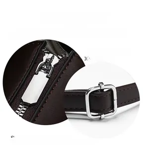 Detailed view of the silver metal zipper and adjustable buckle on dark brown leather bag