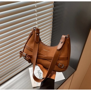 Détail du sac demi-lune en daim marron avec nœud en cuir et boucle en métal