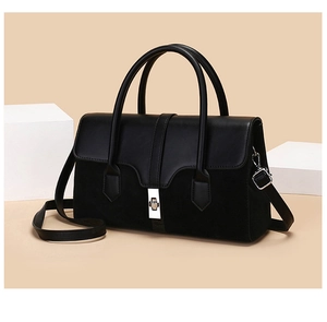 Detail of black bi-material handbag with silver turn-lock and leather suede texture
